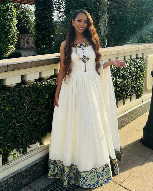 Woman in a white dress with blue and green patterns standing outdoors. Luxury Navy, Gold & Green Zuria Kemis