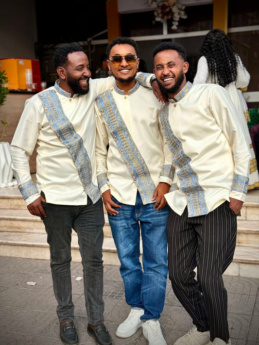 Three men in matching outfits with decorative sashes standing together outdoors. Modern Habesha Shirt for Men New Ethiopian Cultural Tilet Clothing Ethgebya