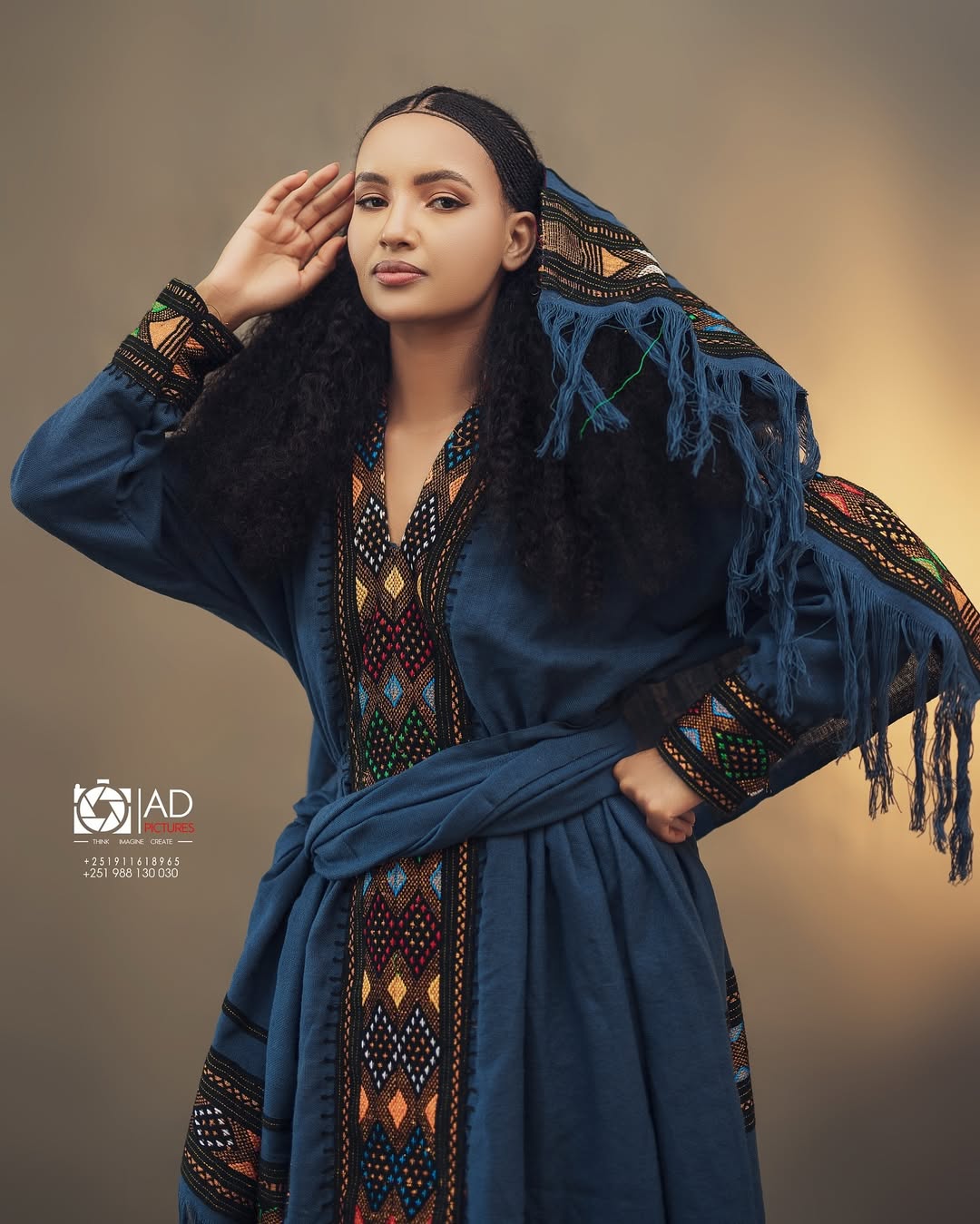 Woman wearing a traditional blue embroidered dress with a headscarf, posing against a neutral background. Dark Blue Raya Cultural Dress Handwoven Ethiopian Habesha Kemis ethgebya gebeya usa habesha kemis