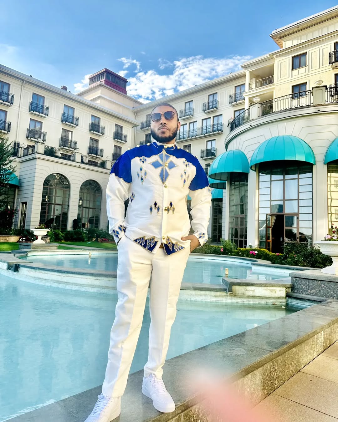 Man in a stylish outfit standing by a pool with a building in the background Blue Habesha Men’s Shirt New Modern Ethiopian Traditional Wear ethgebya gebeya usa habesha mens