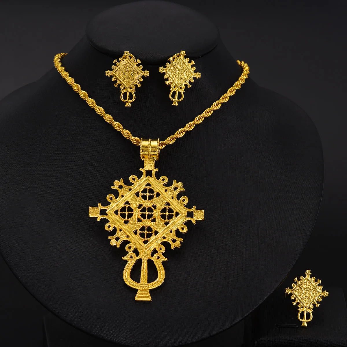 Gold necklace and earrings set on a black background