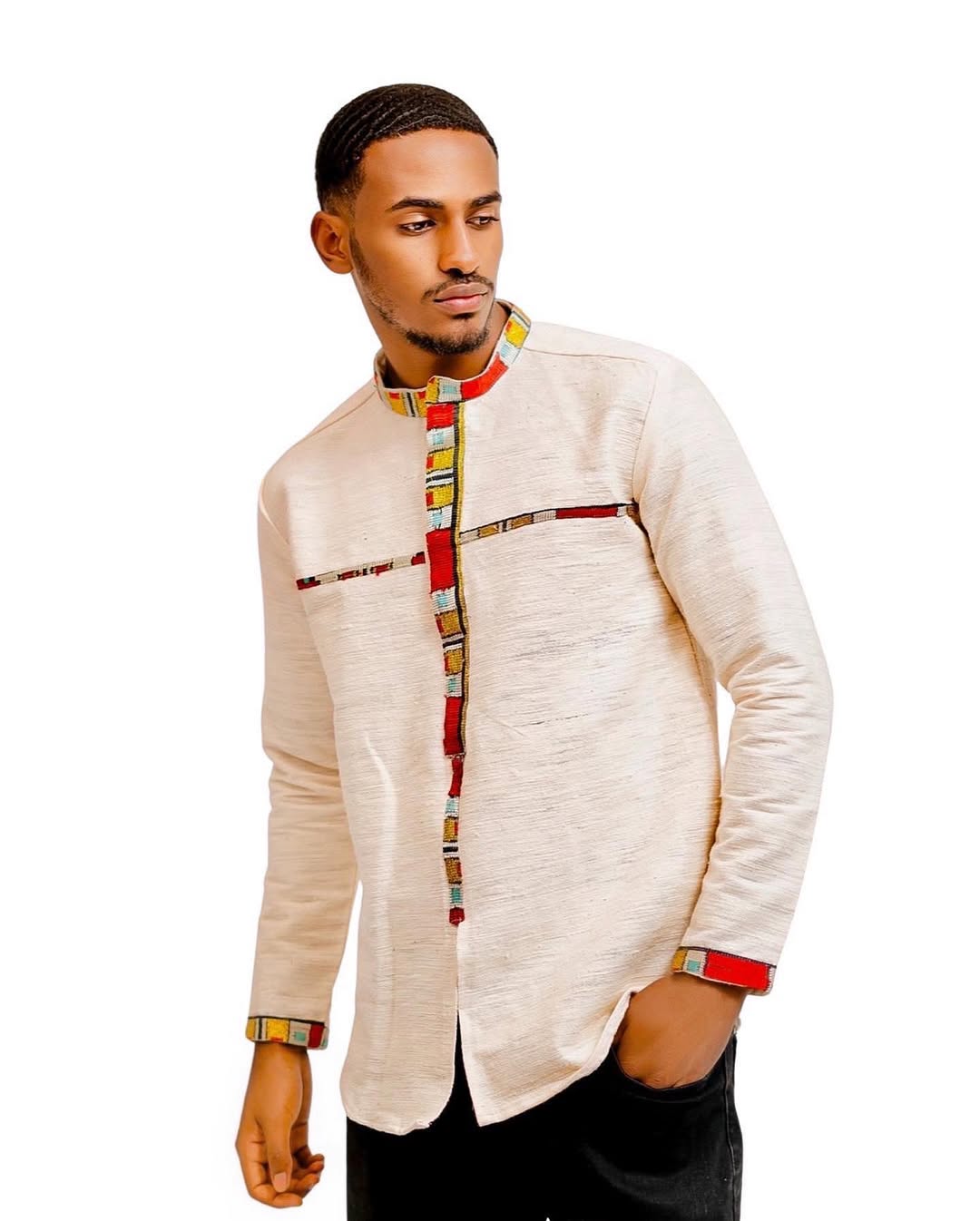 Man wearing a traditional outfit with a white shirt and colorful patterns on a white background 