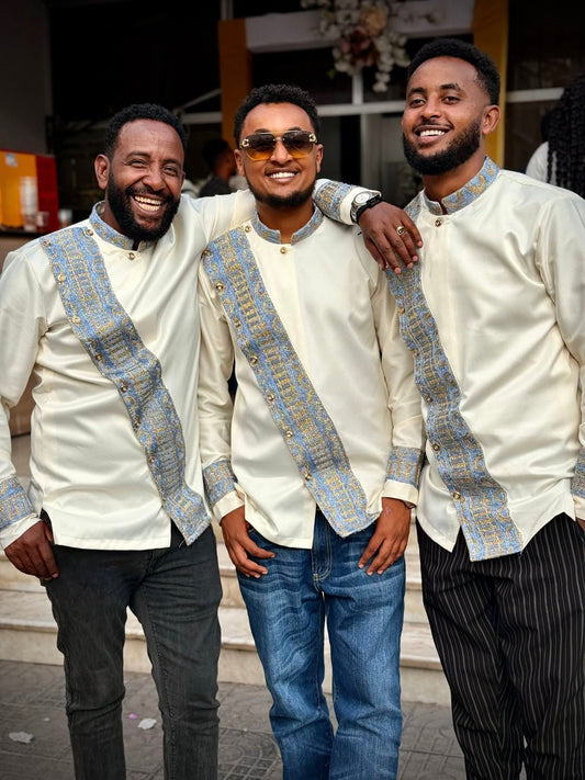 Three men in matching outfits with decorative patterns standing together. Modern Habesha Shirt for Men New Ethiopian Cultural Tilet Clothing Ethgebya
