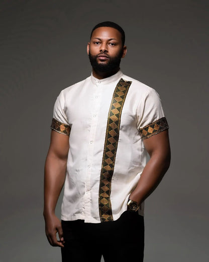 Man wearing a white shirt with gold and black patterns on a gray Modern Habesha Men’s Shirt Stylish Ethiopian Traditional Wearbackground