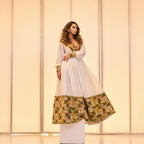 Woman wearing a traditional outfit with a white top and patterned skirt against a neutral background. Golden & Green Modern Zuria Habesha Kemis Ethiopian Traditional Dress ethgebya gebeya