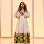 Woman wearing a white dress with gold and green patterns against a light background Golden & Green Modern Zuria Habesha Kemis Ethiopian Traditional Dress ethgebya gebeya