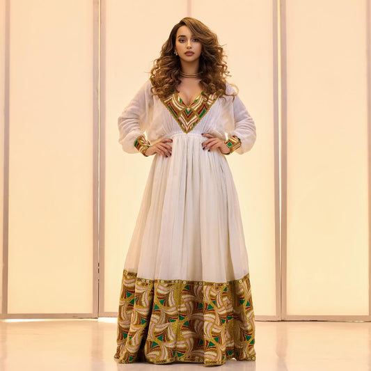 Woman wearing a white dress with gold and green patterns against a light background Golden & Green Modern Zuria Habesha Kemis Ethiopian Traditional Dress ethgebya gebeya
