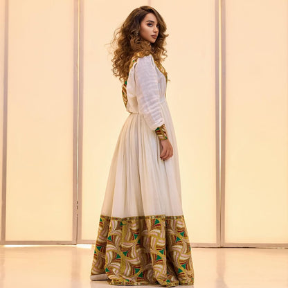 Woman wearing a long, patterned dress with a plain background Golden & Green Modern Zuria Habesha Kemis Ethiopian Traditional Dress ethgebya gebeya