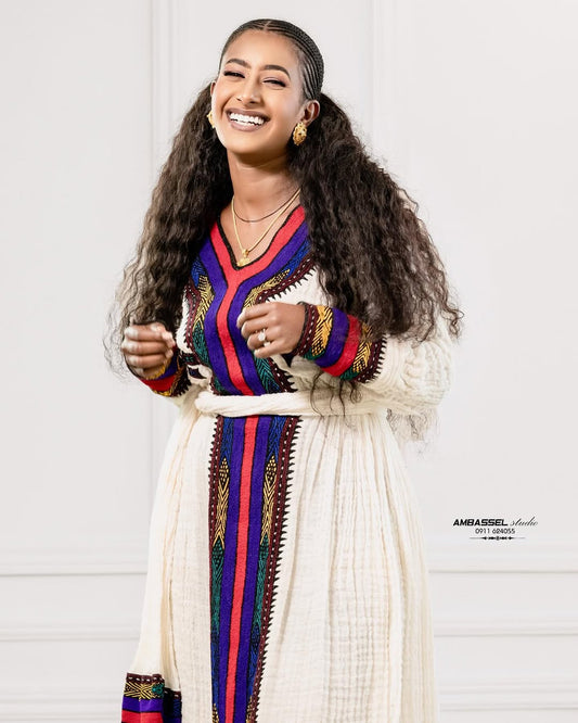 Woman wearing a colorful traditional outfit with a white background Elegant Ethiopian & Eritrean Axum Habesha Dress Ethgebya