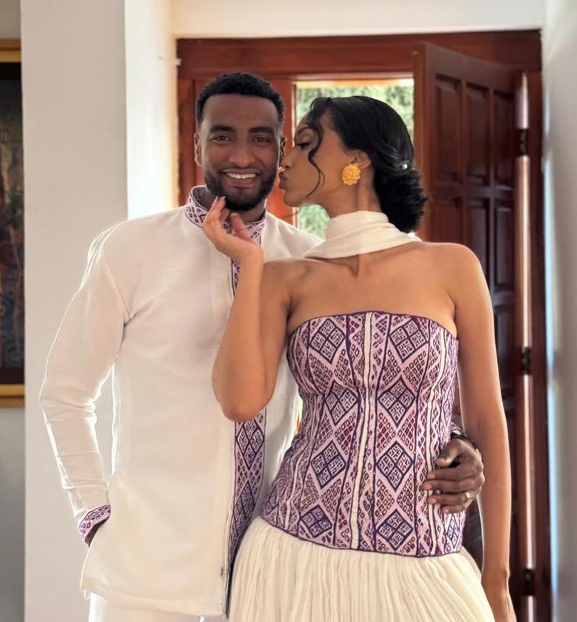 Man and woman standing close together indoors, with a focus on their attire. Purple Habesha Couple Set New Modern Ethiopian Matching Outfits ethgebya gebeya