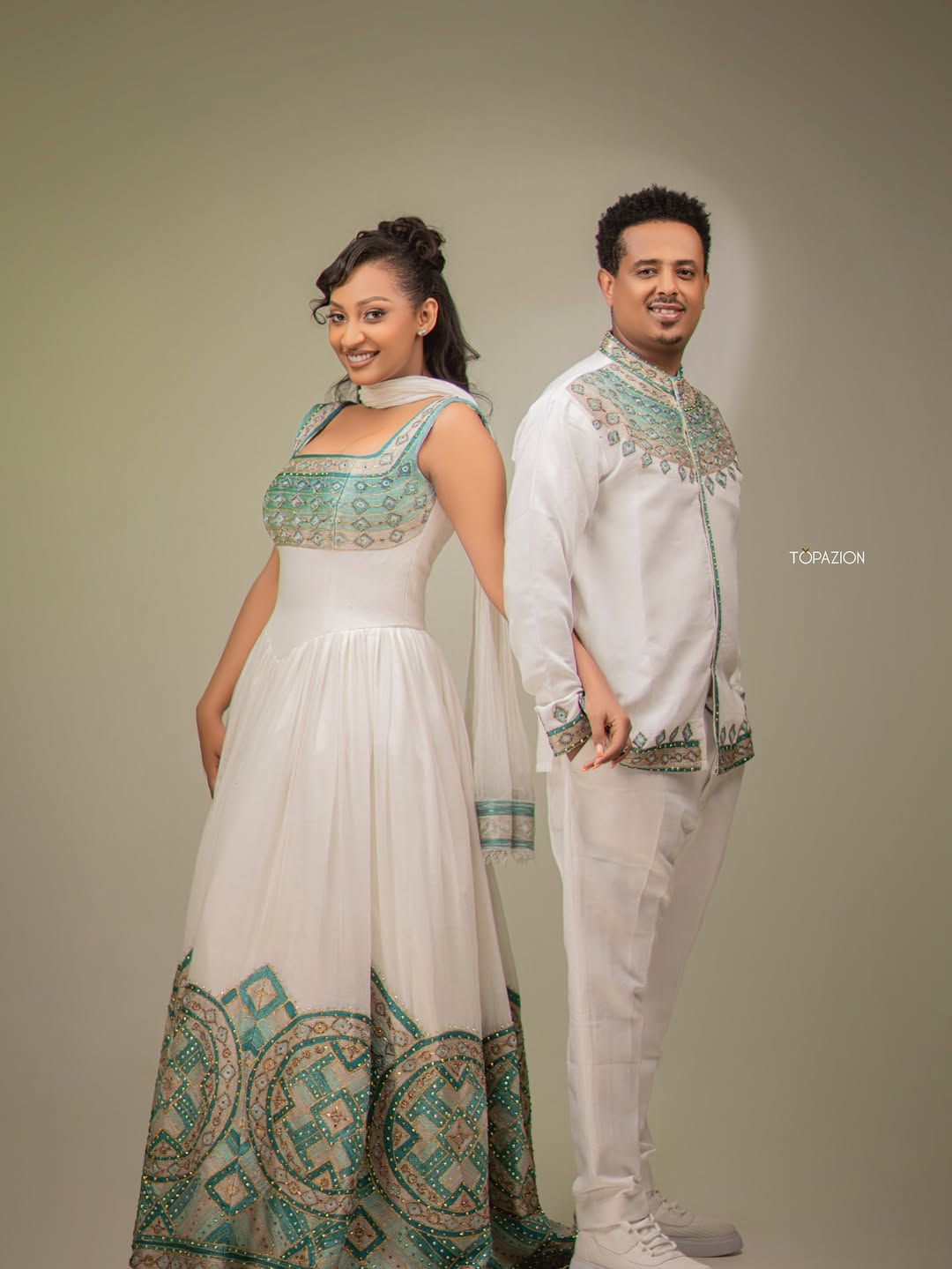 Two people in traditional attire standing against a plain background Habesha Matching Wedding & Cultural Set Ethgebya