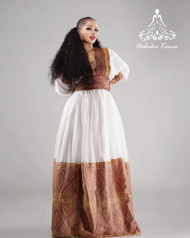 Woman wearing a traditional outfit with a white and brown dress on a gray background Modern Zuria Habesha Kemis Handwoven Ethiopian & Eritrean Dress Ethiopian Gebeya Ethgebya