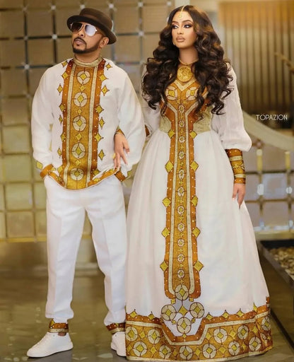 Man and woman in matching traditional outfits with gold and white patterns. Golden Ethiopian Habesha Couple Outfit | New Matching Modern Set