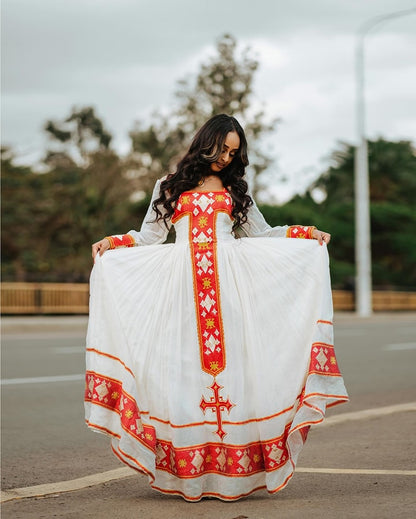 Woman holding a white and red embroidered dress outdoors. Red Zuria Habesha Kemis New Modern Ethiopian Dress ethgebya gebeya usa habesha kemis