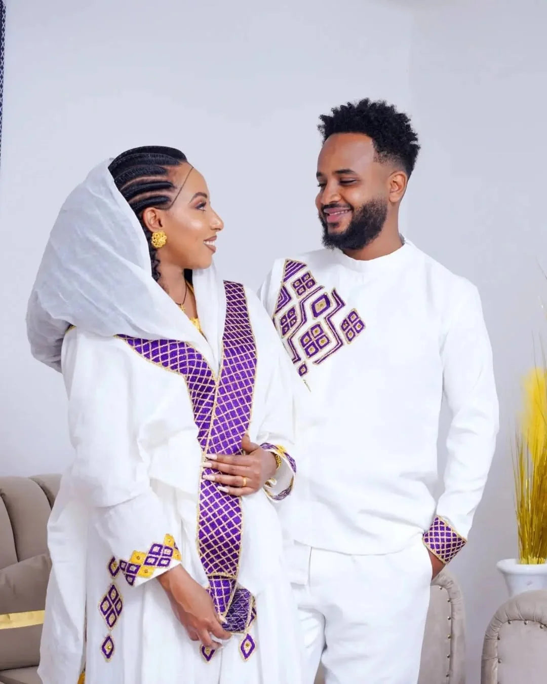 Couple in traditional attire standing close together against a plain background Purple Habesha Couple Outfit New Matching Ethiopian Traditional Set ethgebya gebeya