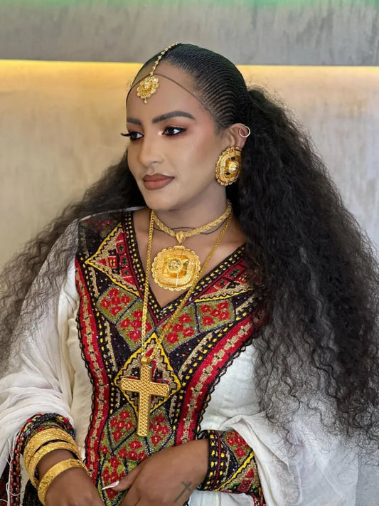 Woman in traditional attire with gold jewelry against a neutral background

axum habesha kemis Shop Now & Enjoy Free Worldwide Shipping – Fast Delivery to USA, Canada, UK, and Europe!