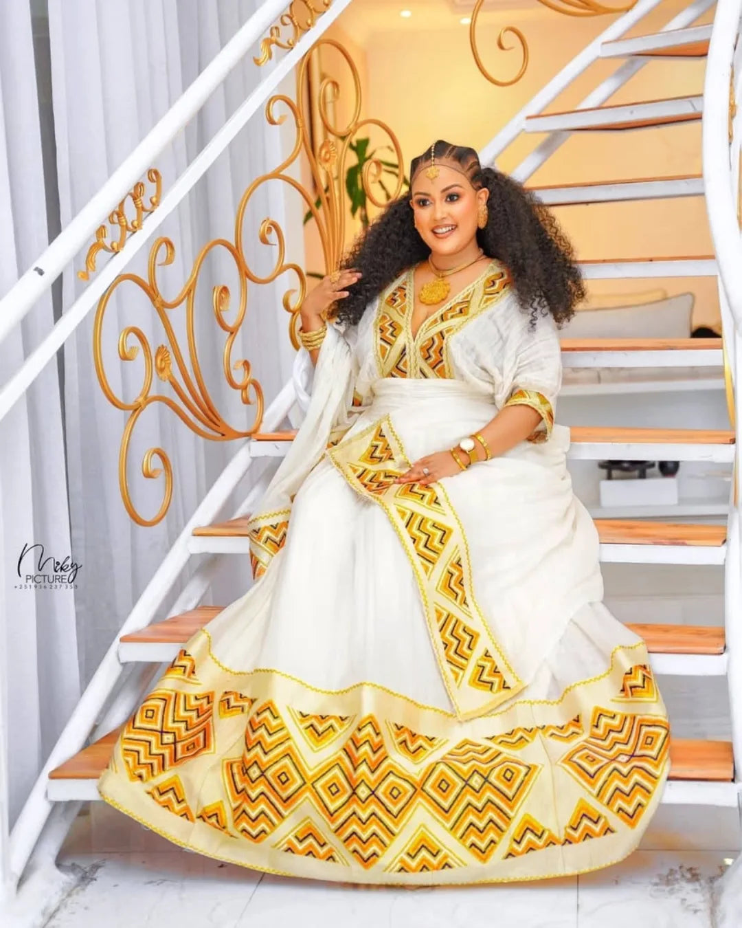 Woman in a white and gold traditional outfit sitting on a staircase. Orange & Yellow Zuria Habesha Kemis Modern Ethiopian Traditional Dress Ethgebya