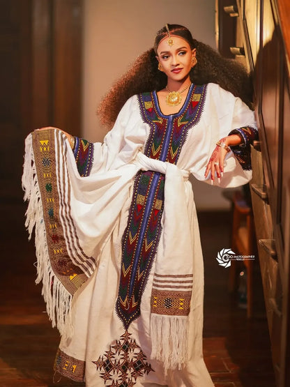 Woman wearing a traditional embroidered outfit with fringes New Ethiopian & Eritrean Axum Habesha Dress Handwoven Tilet Kemis Ethiopia Gebeya Ethgebya