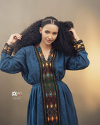 Woman wearing a blue dress with intricate patterns and designs, posing against a plain background. Dark Blue Raya Cultural Dress Handwoven Ethiopian Habesha Kemis ethgebya gebeya usa habesha kemis
