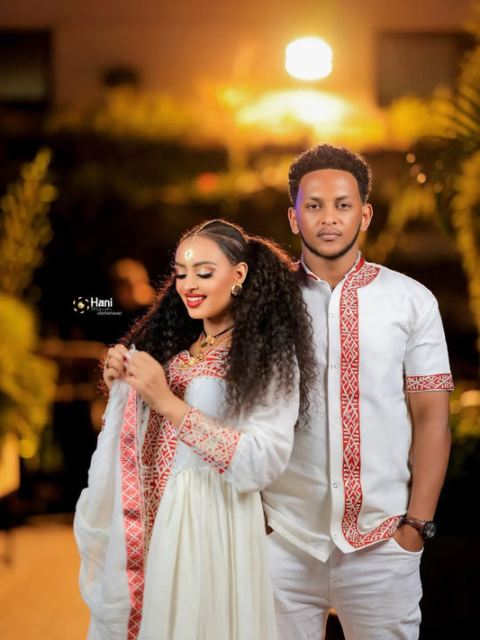 Couple in formal attire standing together with a blurred background Red Ethiopian Couple Set ethgebya