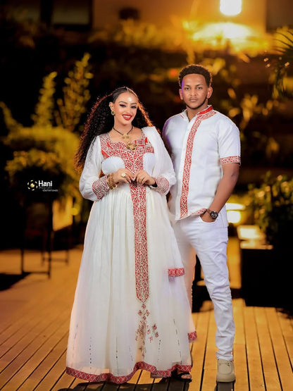 Couple in traditional attire standing on a wooden deck with plants in the background Red Ethiopian Couple Set ethgebya