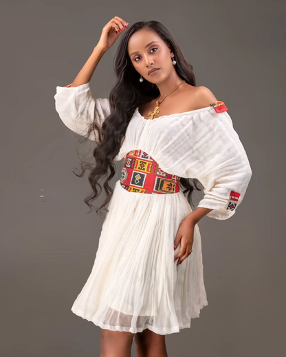Woman wearing a white dress with colorful patterns on a gray background Red Tilet Habesha Short Kemis New Modern Ethiopian Dress ethgebya gebeya