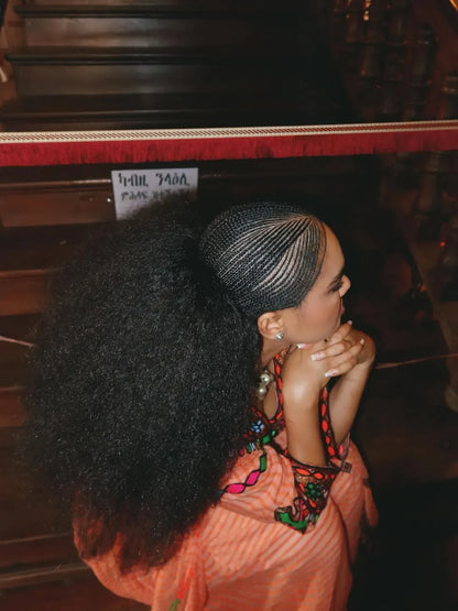 Person with large afro sitting in front of a piano Gold Sand Ethiopian & Eritrean Axum Habesha Dress Ethgebya