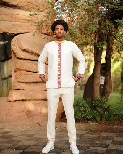 Man in traditional attire standing outdoors with natural background Modern Habesha Men’s Shirt New Elegant Ethiopian Traditional Wear ethgebya gebeya