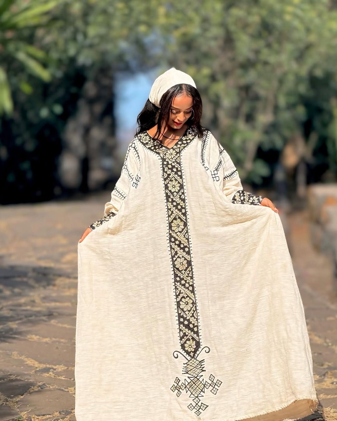 Woman wearing a long, white embroidered dress with a blurred natural background Gonder Habesha Kemis New Relaxed Ethiopian Traditional Dress ethgebya gebeya usa gondar habesha kemis
