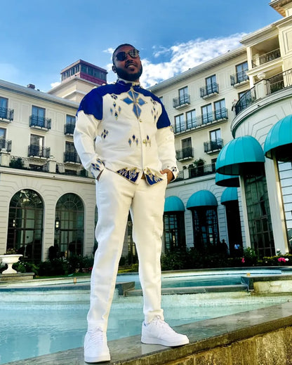 Man in a stylish outfit standing in front of a building with a pool. Blue Habesha Men’s Shirt New Modern Ethiopian Traditional Wear ethgebya gebeya usa habesha mens