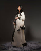 Pregnant woman in a long, light-colored dress with dark accents against a dark background Axum Habesha Kemis & Men’s White Shirt with Gabi Ethiopian Couple Set ethgebya gebeya usa habesha kemis men 