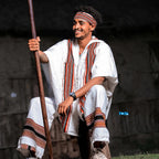 Man in traditional attire holding a long pole against a dark background Oromo Men’s Traditional Clothes Ethiopian Cultural Men's Woya Outfit Ethgebeya