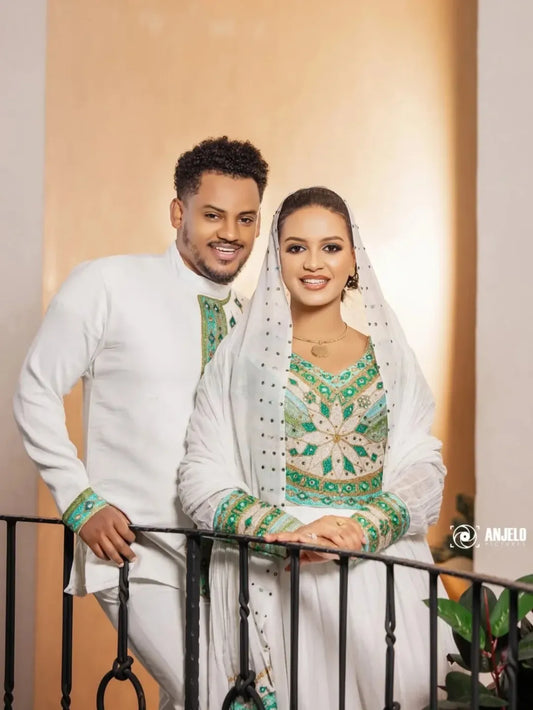 Man and woman in traditional attire standing together on a balcony. Luxury Green Habesha Couple Outfit Matching Ethiopian Attire Set ethgebya gebeya usa habesha couples