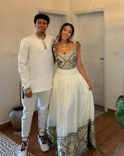 Two people standing together in a room with a neutral background. Luxury Ethiopian Habesha Couple Outfit Matching Modern Attire Set ethiopia gebeya ethgebya