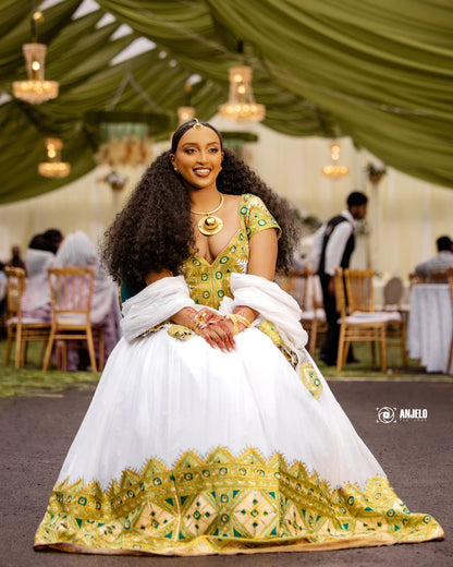Woman in a traditional outfit with green and white patterns at an event.