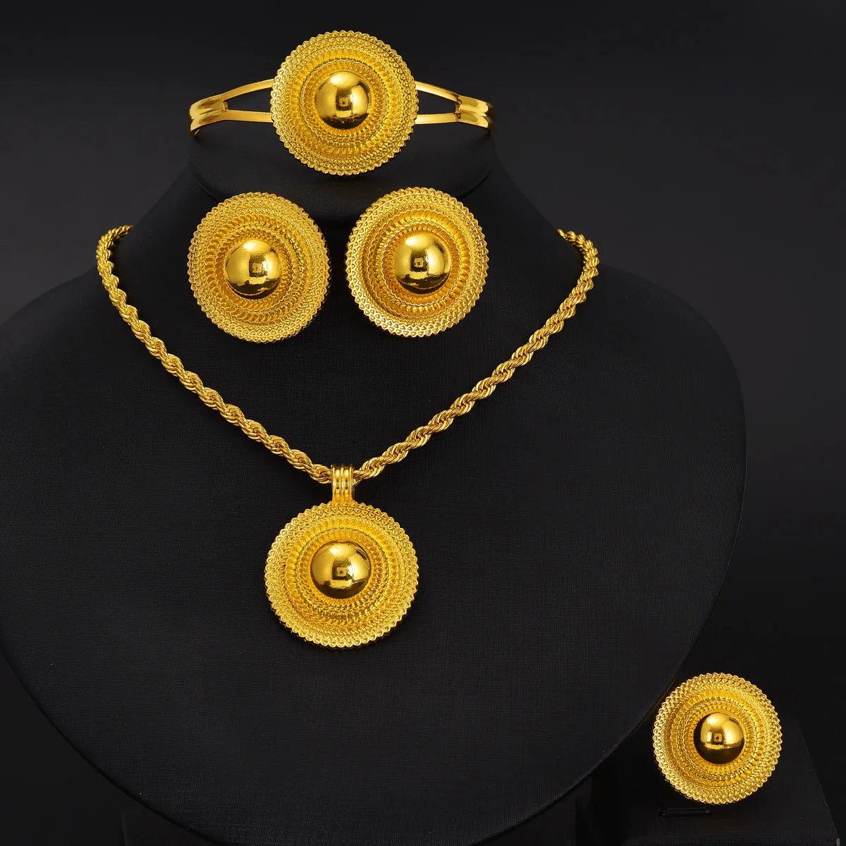 Gold jewelry set including necklace, bracelet, and earrings on a black background