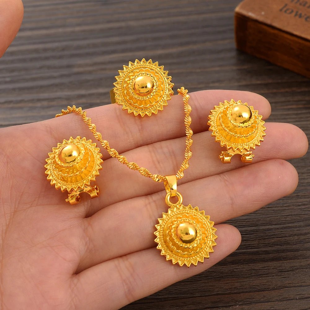Gold necklace and earrings set on a hand with a wooden background