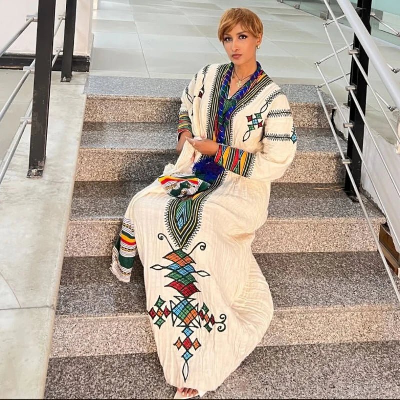Woman in a colorful traditional outfit sitting on a staircase.