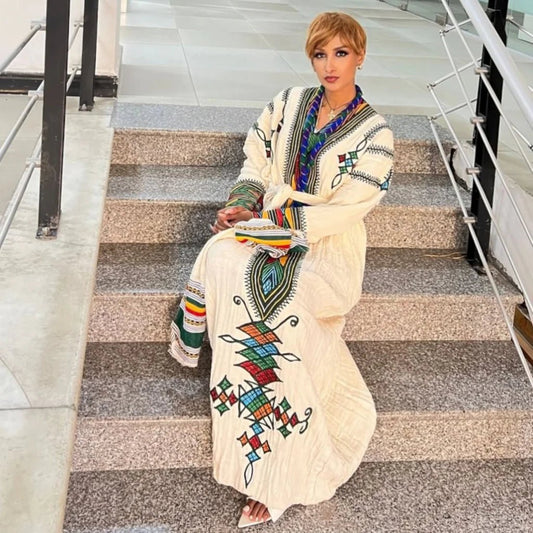 Woman in a colorful traditional outfit sitting on a staircase.