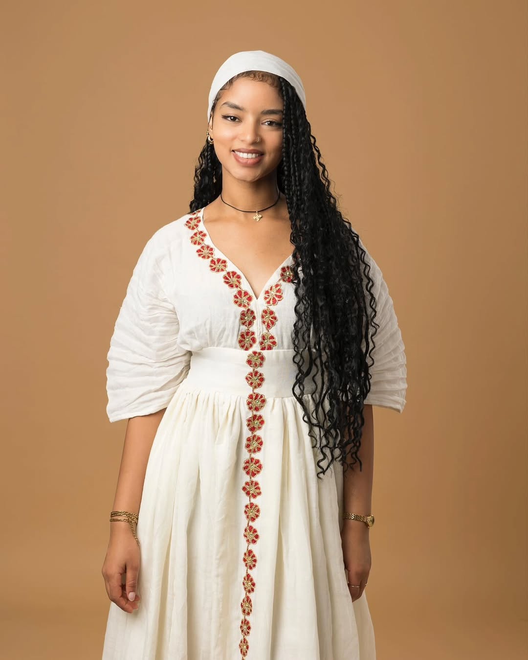 Woman wearing a white dress with floral embroidery on a brown background Red Flower Zuria Habesha Kemis Modern Ethiopian Traditional Dress ethgebya simple habesha kemis gebeya