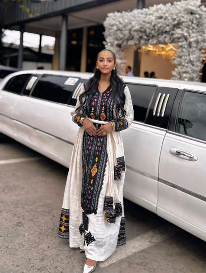 Woman in a patterned dress standing next to a white limousine Special Axum Habesha Kemis | Modern Ethiopian Traditional Dress