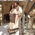 Couple in formal attire standing together in a modern architectural setting
