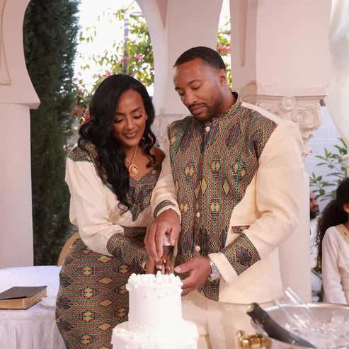 Man and woman cutting a cake together at an event with decorative elements.