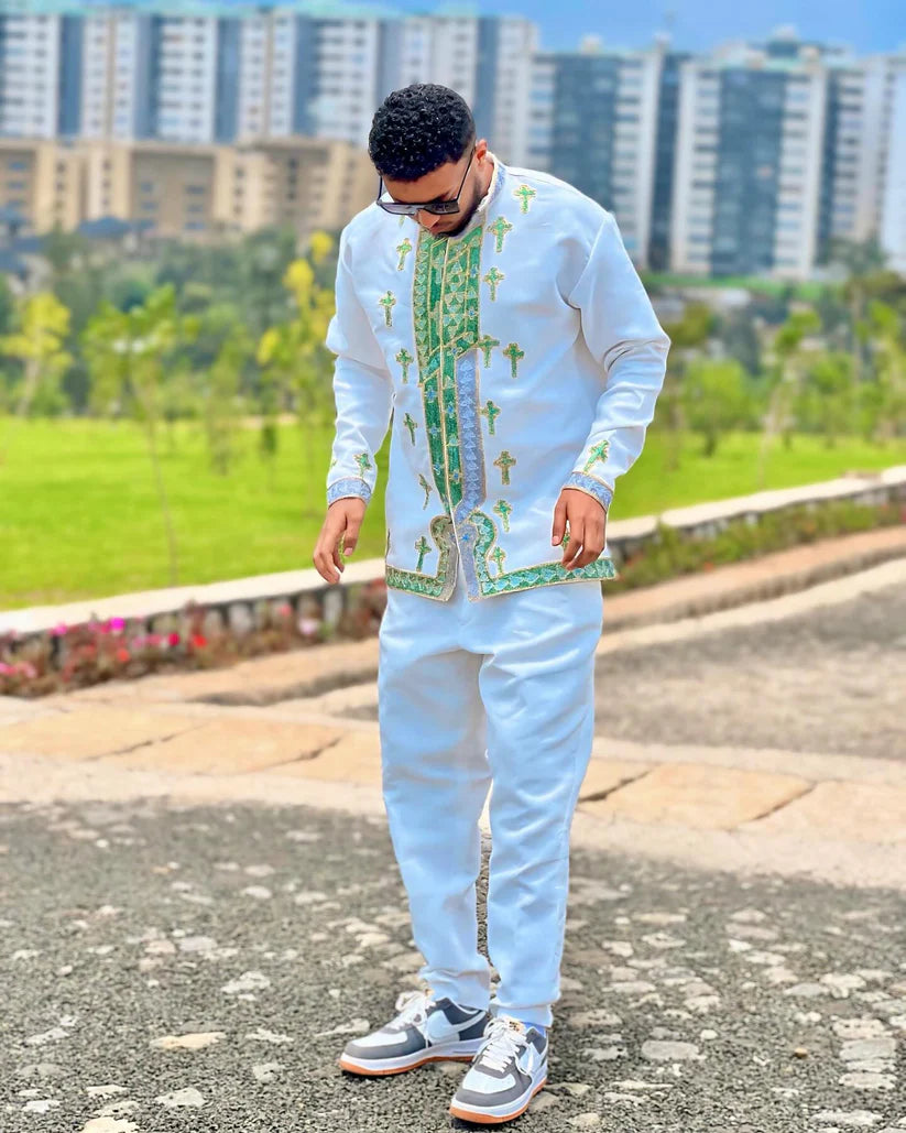 Man wearing a traditional outfit with green patterns in an outdoor setting. Shop Now & Enjoy Free Worldwide Shipping – Fast Delivery to USA, Canada, UK, and Europe! ethgebya