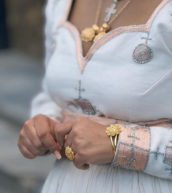 Close-up of a person wearing gold jewelry with a blurred background