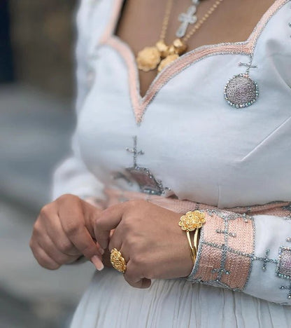 Close-up of a person wearing gold jewelry with a blurred background